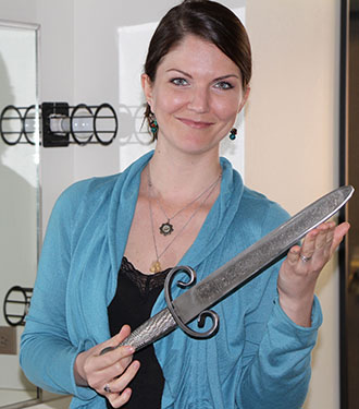 Performing Arts Director Stephanie Newman models with a stage prop short sword.